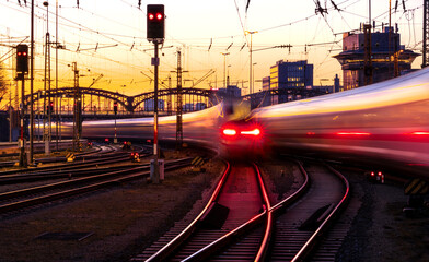 Fast trains leaving and arriving at Munich main station (Germany) in warm evening light. Blurred...