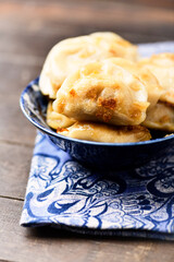 Dumplings with potato and cottage cheese stuffing (pierogi). Wooden background. Close up.