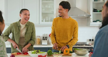 At christmas, diverse friends preparing salad together in kitchen, enjoying cooking and laughing
