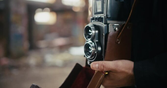 A vintage film camera being opened and set up