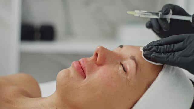 Close-up of a cosmetologist injecting a woman face with precision, focusing on skin rejuvenation, wrinkle removal, and lifting for a youthful and glowing look. High quality 4k footage