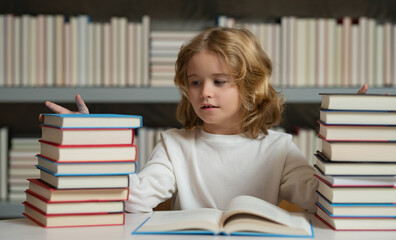 Kid reads books in the library. Schoolboy with book in school library. Literature for reading.