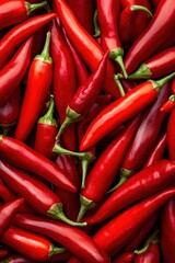 A vibrant closeup of fresh red hot chili peppers with some green stems in a market setting, showcasing their spicy and organic appeal