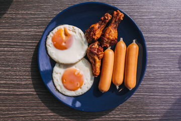 Breakfast set of Fried eggs, sausage and fried chicken wing.