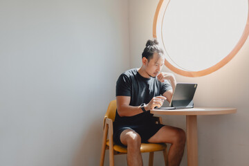 Freelance man work online on computer tablet at corner of cafe.