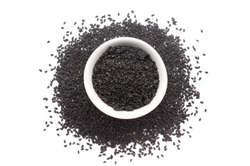 A bowl of Organic Black Sesame (Sesamum indicum) Seeds powder, placed over a heap of whole black...