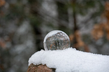 Snow-covered landscape is reflected in a sphere