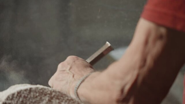 Close-up view about the chiseling stone work details with a working man hand, Italy.