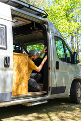 Campervan conversion: man installing mosquito net on door of his van