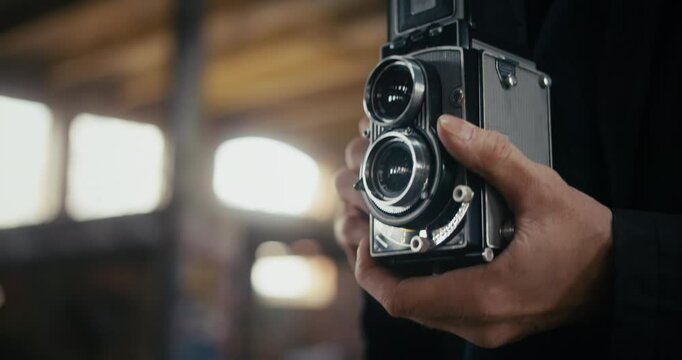 Hands of a male photographer taking pictures with vintage film camera