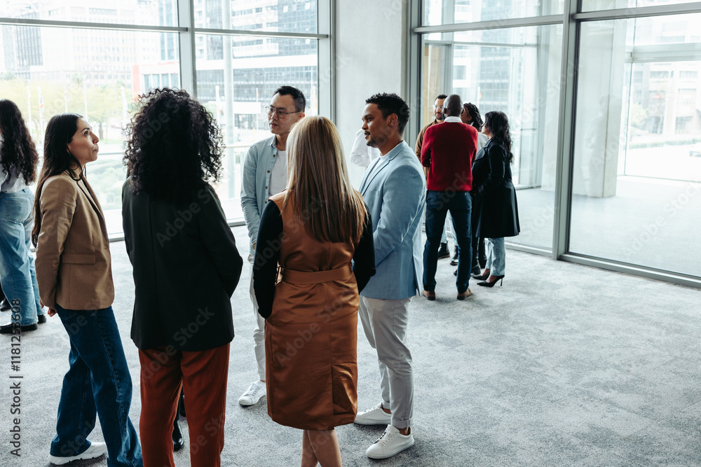 Wall mural group of professionals networking during a conference at a modern office event