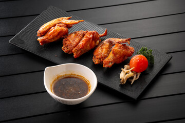 Fried chicken wings on a black slate, Chinese cuisine