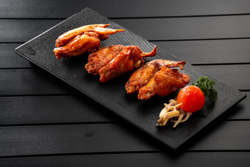 Fried chicken wings on a black slate, Chinese cuisine