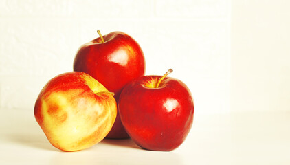Ripe red apples on a light background