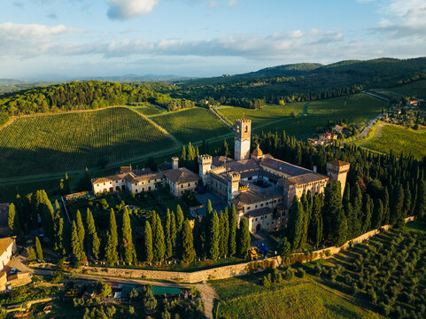 Aerial view of the beautiful Abbey of San Michele Arcangelo a Passignano surrounded by scenic vineyards and cypress trees, Barberino Tavarnelle, Italy.