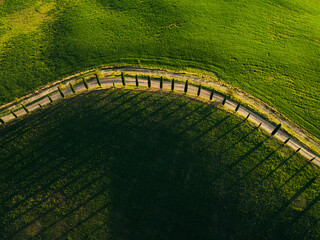 Aerial view of picturesque vineyards and serene fields with a winding road, Monteroni d'Arbia, Italy.