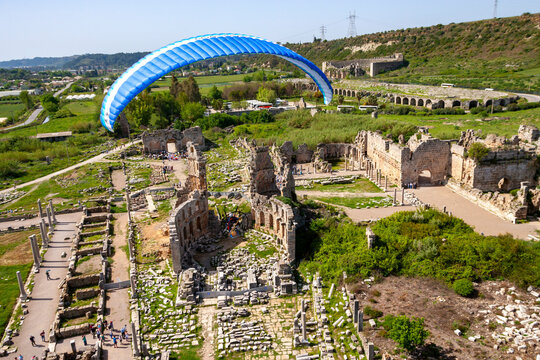 Aerial view of ancient ruins of Perge with scenic landscape and paramotor, Antalya, Turkey.