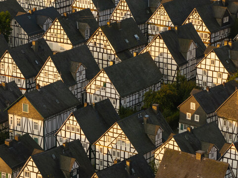 Aerial view of charming half-timbered houses in a historic village at sunrise, Freudenberg, Germany.