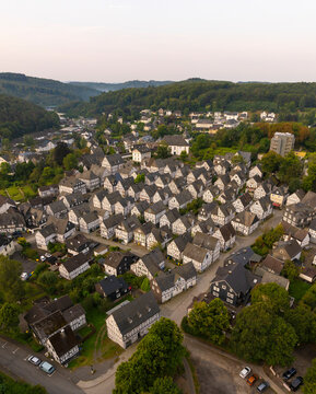Aerial view of historic half-timbered houses in a scenic village surrounded by forest, Freudenberg, Germany.