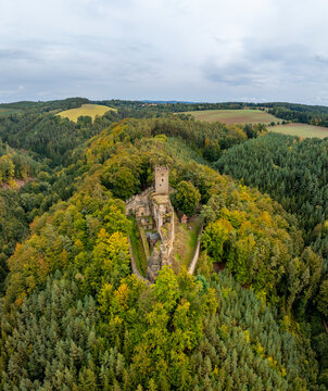Aerial view of the abandoned medieval Burg Helfenburk castle surrounded by lush autumn forest and trees, Ustek, Czech Republic.