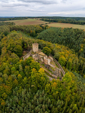Aerial view of the abandoned medieval Burg Helfenburk castle surrounded by autumn forest and trees, Ustek, Czech Republic.
