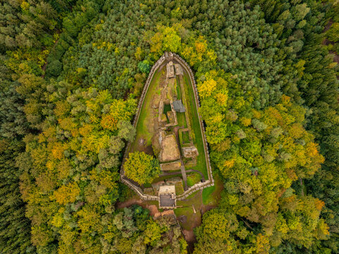 Aerial view of the abandoned medieval Burg Helfenburk castle surrounded by a serene autumn forest, Ustek, Czech Republic.