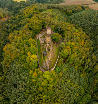 Aerial view of the abandoned medieval Burg Helfenburk castle surrounded by autumn forest and trees, Ustek, Czech Republic.