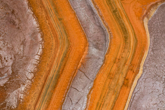 Aerial view of abstract mineral deposits and colorful patterns at Redbank salt farm, Port Hedland, Australia.