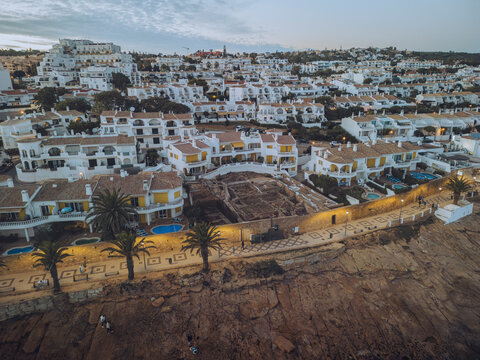 Aerial view of praia da luz with white washed houses and palm trees at sunset, Faro, Portugal.