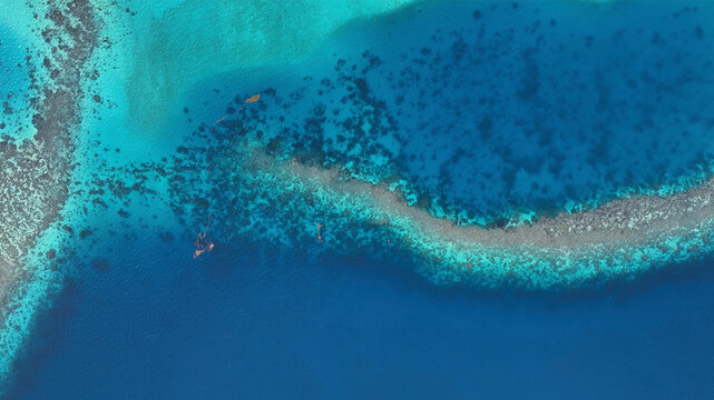 Aerial view of abstract reef and beautiful island in clear blue ocean, Eastern Fiji.
