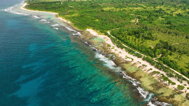Aerial view of beautiful tropical island with clear turquoise waters, lush palms, and serene waves, Shefa, Vanuatu.