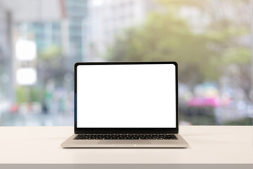 close up blank white screen display of laptop computer on table in office building with city scene...