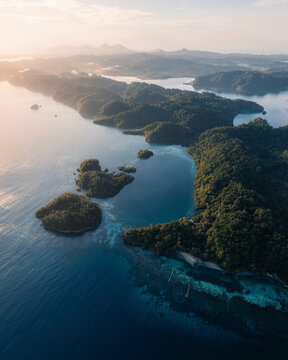 Aerial view of serene Kididiri Resort with lush green islands and tranquil lagoon, Tojo Una Una Regency, Indonesia.