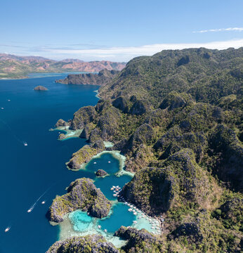 Aerial view of beautiful tropical island with crystal clear water and lush greenery, Banuang Daan, Coron, Philippines.