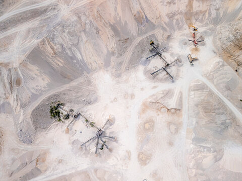 Aerial view of an industrial quarry with heavy machinery and dusty terrain, Bila, Bosnia and Herzegovina.