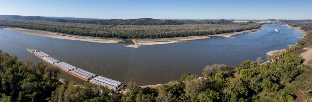 Aerial view of the serene Mississippi River panorama with barge traffic and lush forests, Valmeyer, United States.