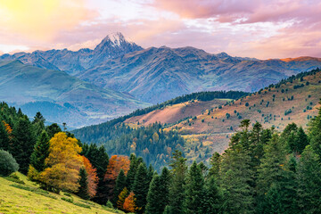 Obraz premium The majestic Pyrenean peak of Pic du Midi d’Ossau rises above lush autumn forests and vibrant valleys, capturing nature’s harmony and beauty in stunning contrast.