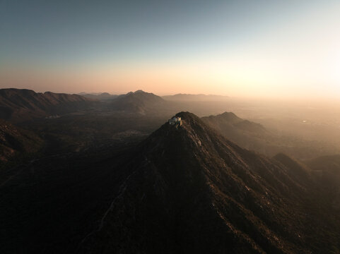 Aerial view of the serene Shree Savitri Mata Temple atop a majestic mountain at sunset, Pushkar, Rajasthan, India.