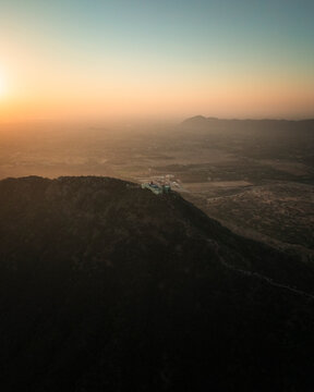 Aerial view of the serene Shree Savitri Mata Temple amidst the majestic mountains at sunset, Pushkar, Rajasthan, India.