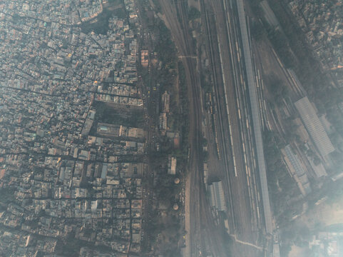 Aerial view of bustling Pahar Ganj with vibrant railway tracks and dense urban architecture, New Delhi, India.
