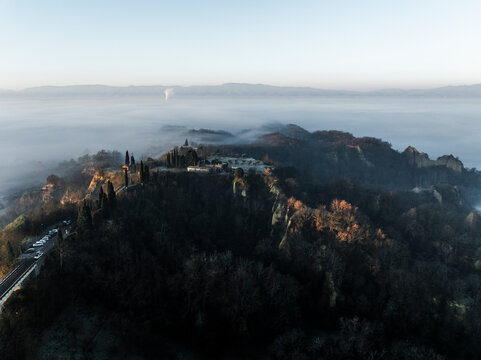 Aerial view of serene hills and a picturesque valley shrouded in fog at sunrise, Tuscany, Reggello, Italy.