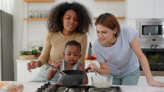 child boy cooking some food with family and eating apples in the kitchen
