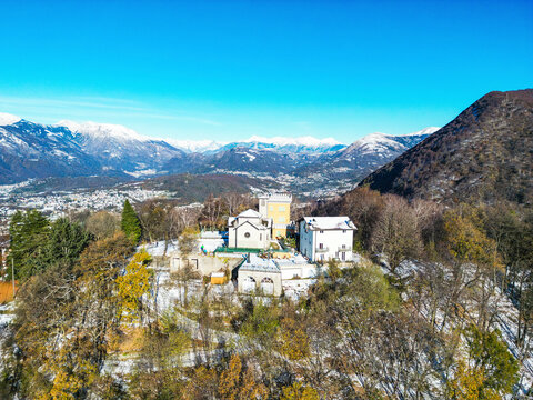 Aerial view of picturesque Monte Bre with beautiful houses and serene trees in a tranquil winter landscape, Bre sopra Lugano, Switzerland.