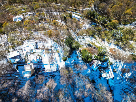 Aerial view of picturesque snow-covered homes and tranquil forest in winter, Bre sopra Lugano, Schweiz.