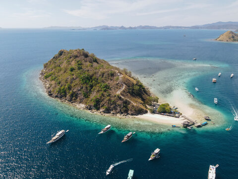 Aerial view of beach and tourist boat sailing in Kelor Island, Labuan Bajo, Indonesia.