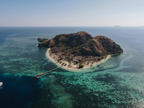 Aerial landscape view of Kanawa Island beach with long bridge dock.