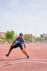 A man in a blue shirt is playing basketball on a court.