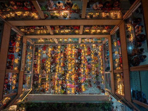 Aerial view of colorful candles and lights during Kartik Vrata festival with a large crowd at a temple, Gendaria, Dhaka, Bangladesh.