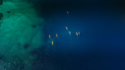Aerial view of tranquil kayaks on a serene fjord surrounded by beautiful landscapes, Hamnoy, Norway.