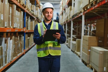 Portrait of warehouseman with clipboard checking delivery, stock in warehouse. Warehouse worker...